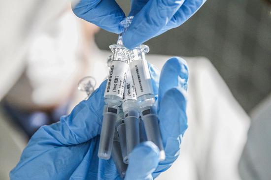 File photo shows a staff member displays samples of the COVID-19 inactivated vaccine at Sinovac Biotech Ltd., in Beijing. (Xinhua File/Zhang Yuwei)