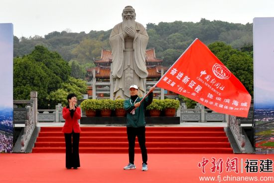 漳州市副市长余向红（左）向海外华文媒体代表授旗。吕明 摄